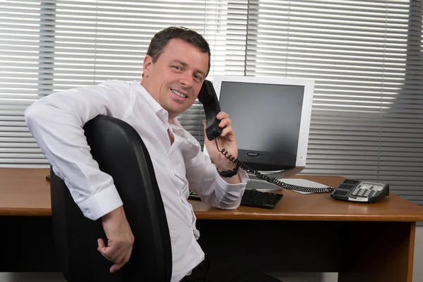 Fröhlicher Mann im Amt am Telefon — Stockfoto