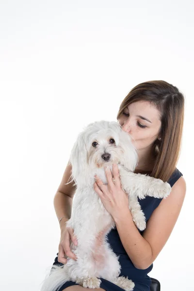 Joven hermosa mujer besando a su perrito aislado sobre fondo blanco — Foto de Stock