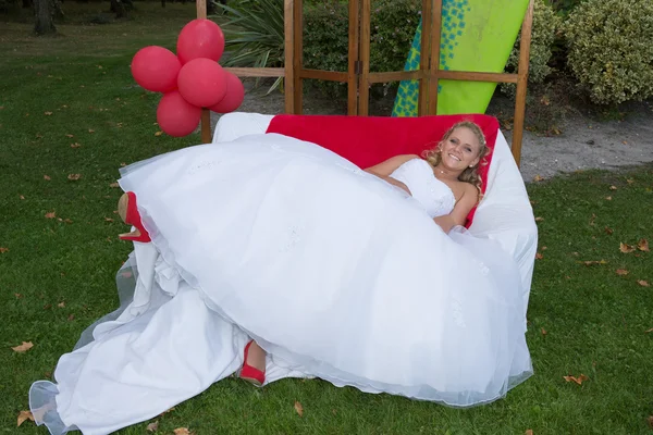Красивая невеста лежит на диване в лесу — стоковое фото