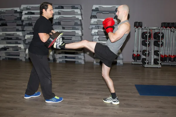 男性の物理的な演習を行うとフィットネス センターでボクシングの練習 — ストック写真