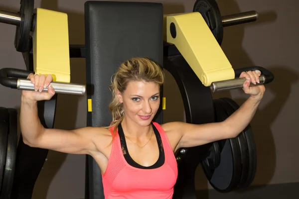 Mutlu kadın kürek makine spor salonunda egzersiz — Stok fotoğraf
