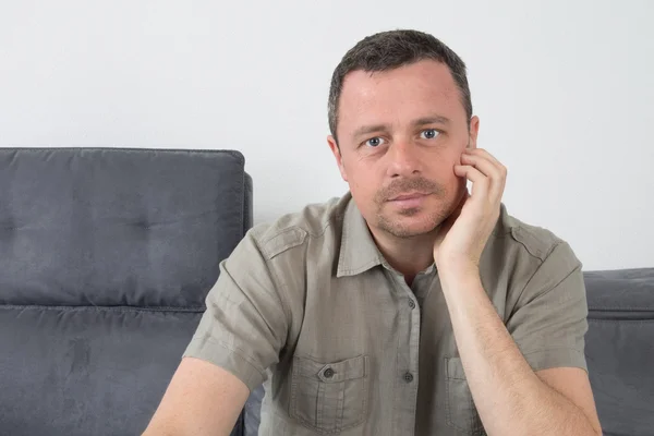 Man thinking and looking to the camera, holding his chin