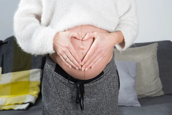 妊娠中の女性の手で彼女の腹に触れる — ストック写真
