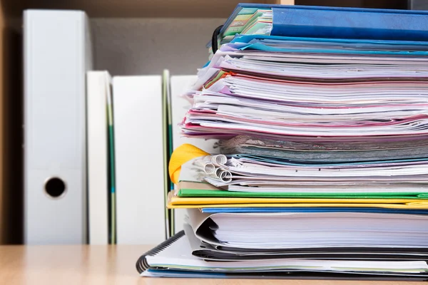 Close-up of file folders next to shelves at office — Stock Photo, Image