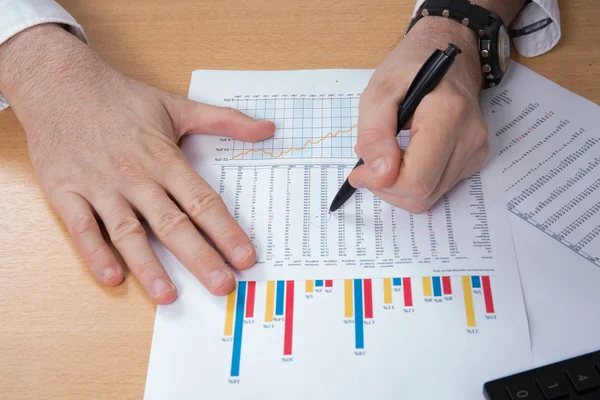 Nahaufnahme eines Geschäftsmannes, der mit dem Taschenrechner am Schreibtisch die Rechnung prüft — Stockfoto