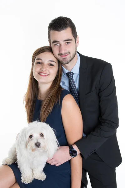 Casal feliz acariciando cão enquanto sentado no sofá em casa — Fotografia de Stock