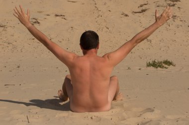 Nudist young caucasian man seen from behind relaxing on the seashore, filtered clipart