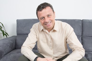 Evde kanepede oturan rahat bir adam portresi