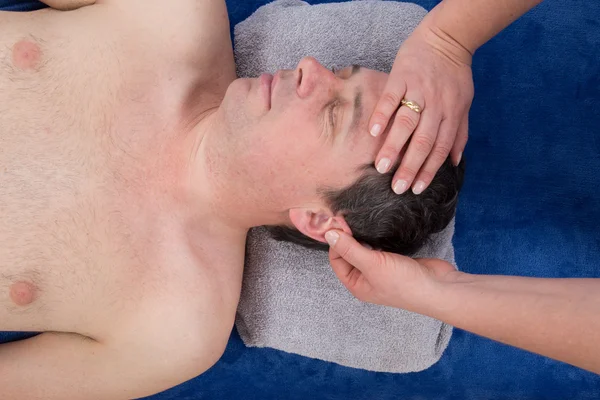 Masaż terapeuta robi masaż ucha na mężczyzna na białym tle — Zdjęcie stockowe