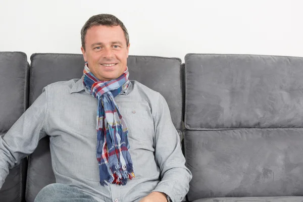 Happy man on the couch smiling — Stock Photo, Image