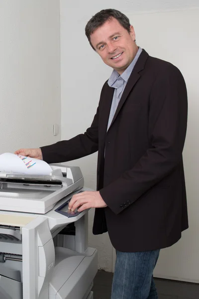 Vista lateral del hombre de negocios manteniendo papel en la fotocopiadora — Foto de Stock