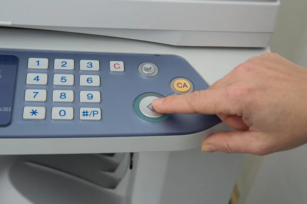 Mão pressionando o botão Iniciar na máquina de cópia — Fotografia de Stock