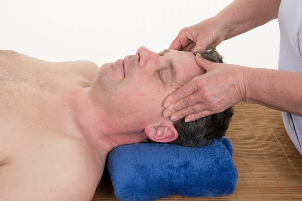 Masażysta robi masaż głowy świątyń na człowieka w salonie spa. — Zdjęcie stockowe