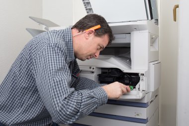 Frustrated technician man opening photocopy machine in office to fix problem clipart