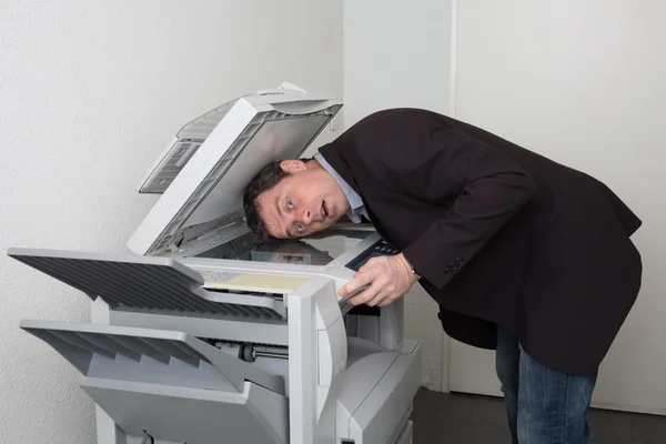 Obchodní muž v nesnázích s copy stroj při práci — Stock fotografie