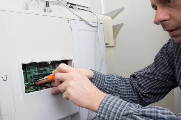 Handyman fijando la impresora de la oficina en una oficina — Foto de Stock