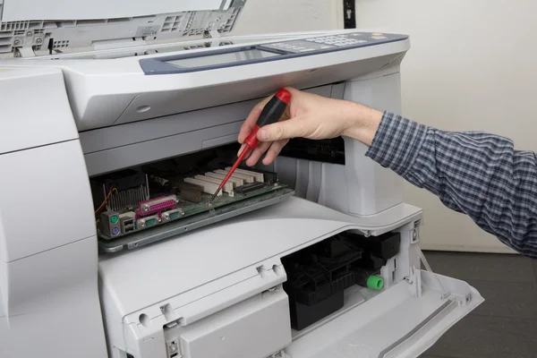 Tratando de reparar la impresora de oficina en un lugar de negocios brillante — Foto de Stock