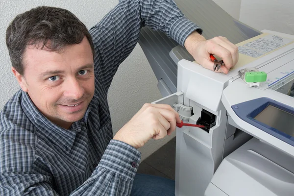 Handyman fixando a impressora de escritório ou máquina de cópia — Fotografia de Stock