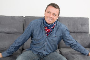 Kanepe rahat kıyafetler üzerinde bir eşarp ile Amerikalı adam
