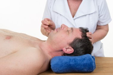 Bir akupunktur tedavisi bir Spa merkezindeki gülümseyen adam