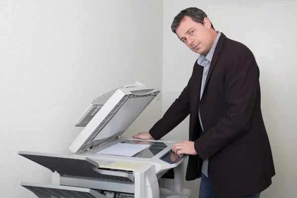 Empresário mantendo papel na fotocopiadora no escritório — Fotografia de Stock