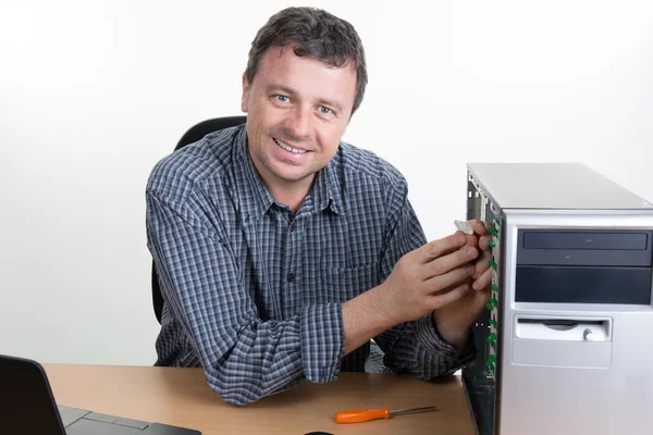 Fröhlicher Computeringenieur arbeitet am offenen Rechner im hellen Büro — Stockfoto