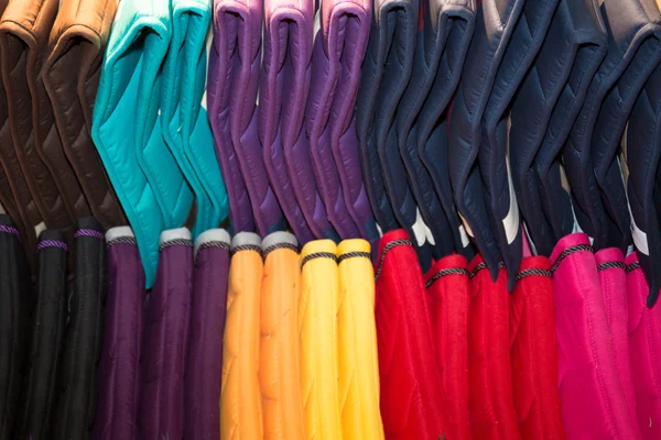 Regenboog kleding achtergrond. Stapel van heldere gevouwen kleding. — Stockfoto