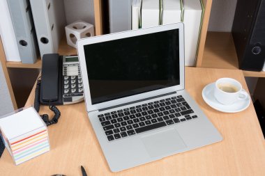 Fincan kahve ve ahşap zemin üstünde laptop 