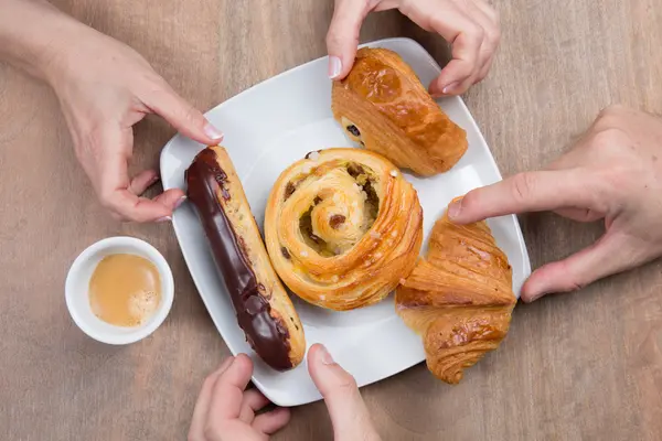 Coffee and croissants in cafe, hands of couple a closeup — Stock Photo, Image