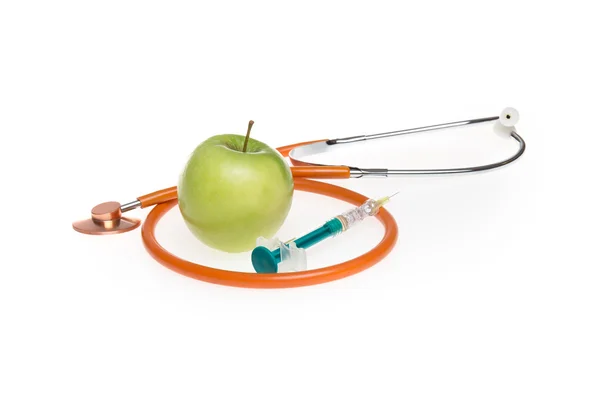 Gula äpple med stetoskop och spruta isolerade — Stockfoto