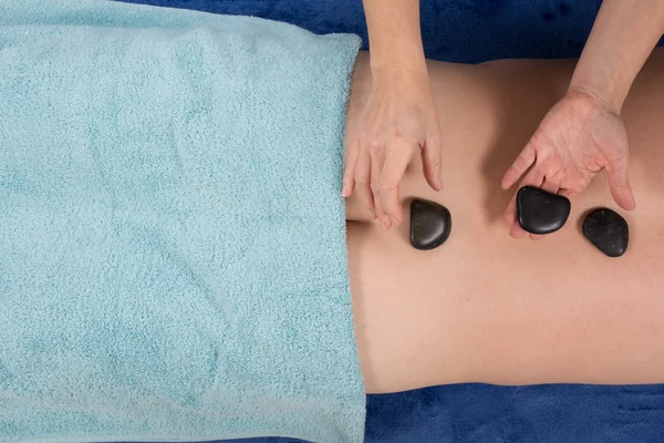 Homem fazendo massagem de pedra no salão de spa. Estilo de vida saudável . — Fotografia de Stock