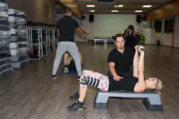 Onun kişisel bir eğitmen ile egzersiz jimnastik salonu kadın — Stok fotoğraf