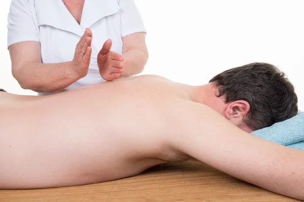 Masajista haciendo masaje en el cuerpo del hombre en el salón de spa . —  Fotos de Stock