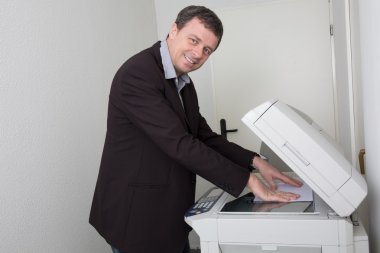 Businessman who makes a photocopy at business place  clipart