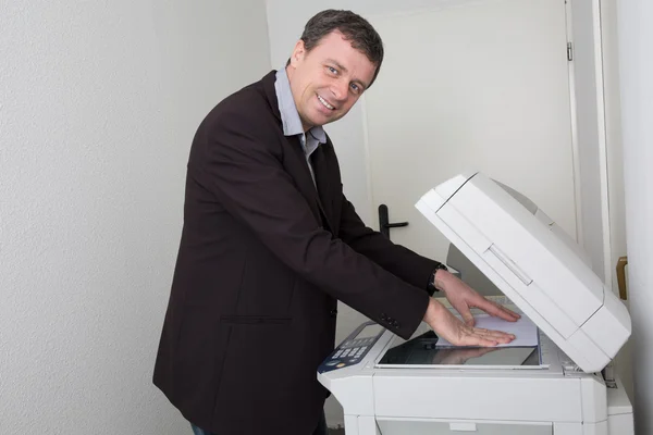Uomo d'affari che fa una fotocopia sul posto di lavoro — Foto Stock