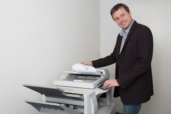 Uomo d'affari che fa una fotocopia al lavoro — Foto Stock