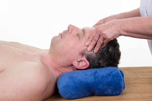 Female sports massage therapist holding male client's head and massaging tight neck muscles with finger and thumbs — Stock Photo, Image