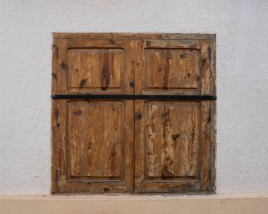 Beyaz duvarla çerçevelenmiş ahşap bir köy penceresinin ayrıntıları