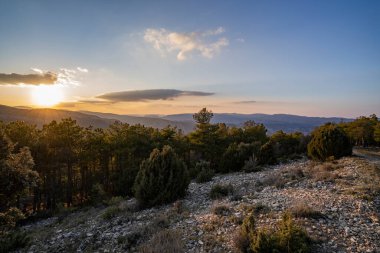 Taşlar ve çalılarla kaplı bir arazide gün batımı