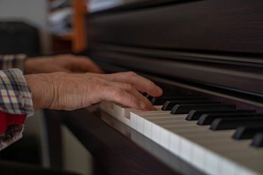 Piyano çalan kıdemli bir adamın ellerinin ayrıntıları.
