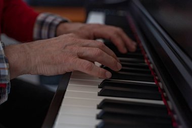 Piyano çalan kıdemli bir adamın ellerinin ayrıntıları.
