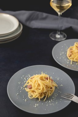 Geleneksel İtalyan spagetti carbonara krema soslu ve koyu arkaplanda. Kopyalama alanı ile yakın plan görünüm.