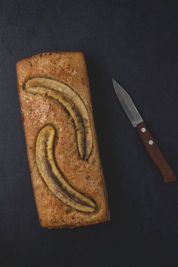 Ev yapımı muzlu fındıklı ekmek koyu arka planda izole edilmiş. Tablo üst görünümü ve kopyalama alanı.