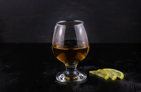 Glas Cognac Met Citroen Close Een Donkere Houten Ondergrond — Stockfoto