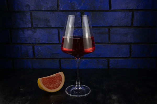 Verre Vin Rouge Une Tranche Pamplemousse Sur Fond Bois Sombre — Photo