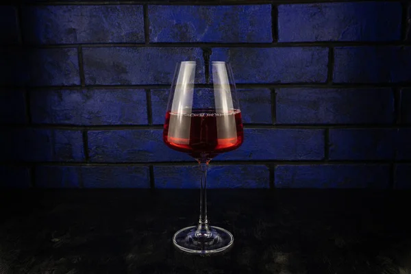 A glass of red wine on a dark wooden background