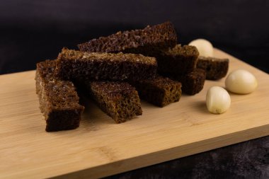 Çavdar ekmeği, yakın plan sarımsaklı, hafif ahşap tahta üzerinde..