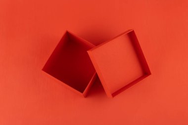 Kırmızı arka planda kırmızı hediye kutusu, üst görünümde.