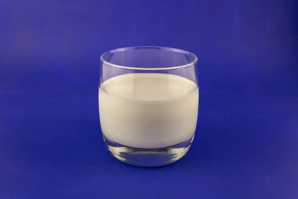 蓝色底色的玻璃杯中的健康牛奶 — 图库照片