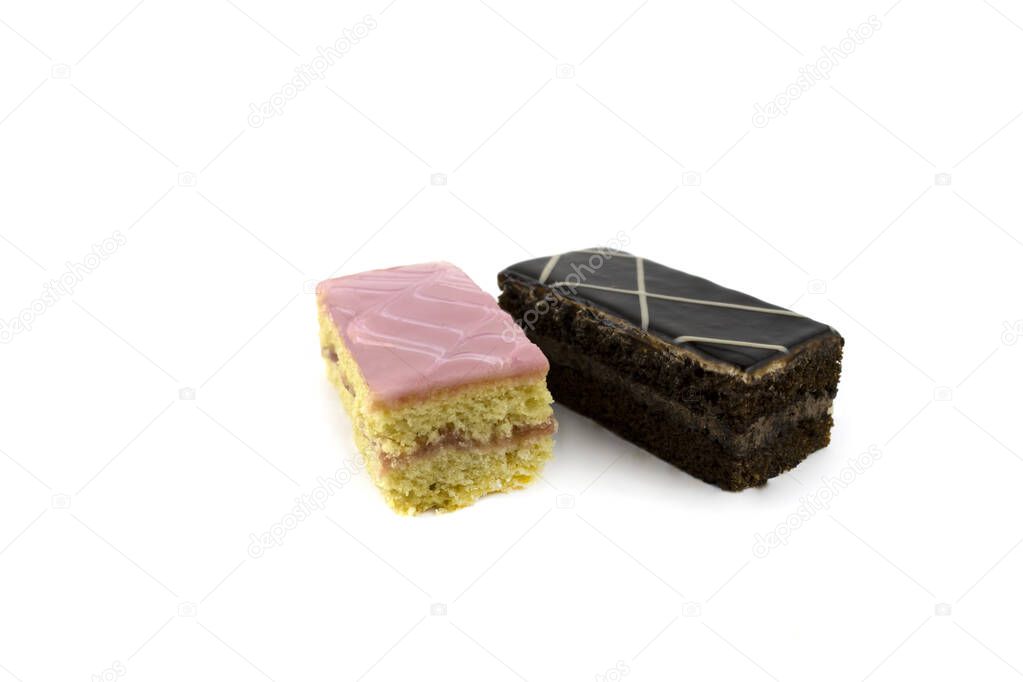 two delicious sponge cakes with cream of pink caramel and chocolate icing isolated on a white background close up